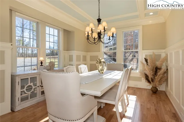 a view of a dining room with furniture wooden floor and chandelier