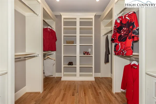 a view of walk in closet with clothes and shoes