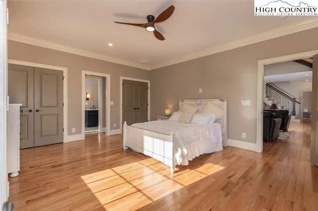 a spacious bedroom with a bed and wooden floor
