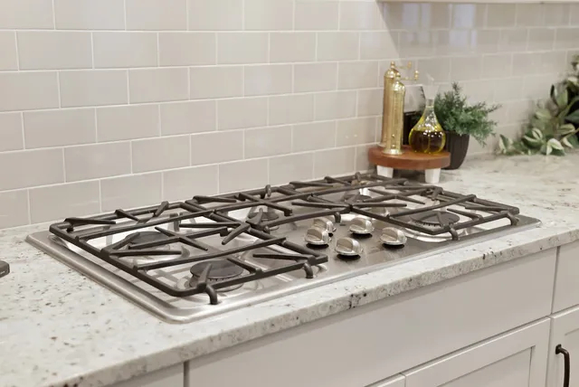 a kitchen with stainless steel appliances granite countertop a sink a stove a refrigerator and island with wooden floor