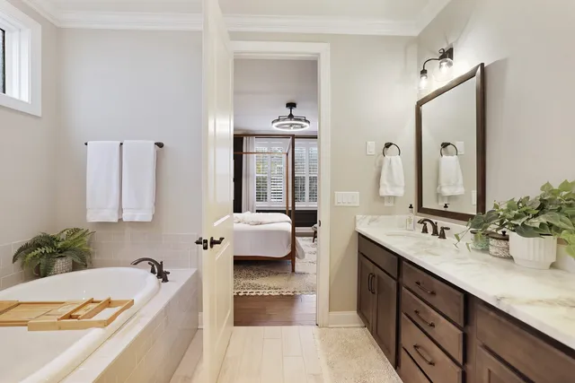 a bathroom with a sink double vanity granite tub shower and a mirror