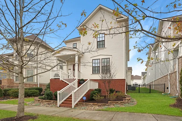 a view of a white house next to a yard