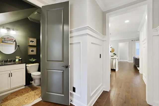 a view of a hallway with wooden floor and a cabinet