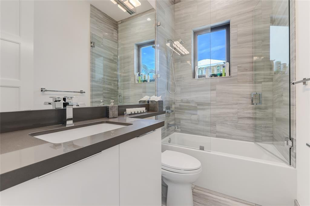 2550 Northeast 31st Court Lighthouse Point, FL 33064 - Photo 56 of 84 a bathroom with a granite countertop bathtub sink vanity mirror and toilet