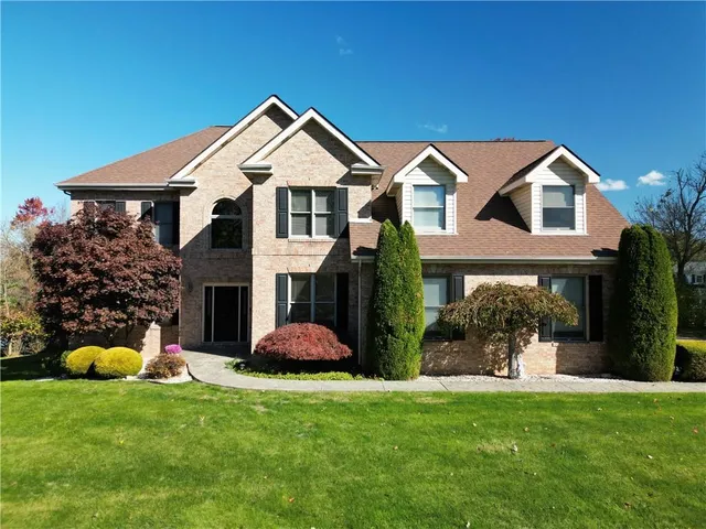 a front view of a house with a yard and potted plants