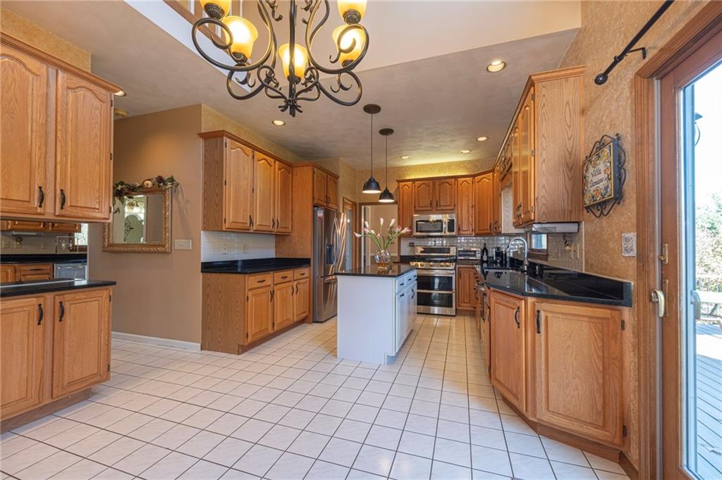 309 Jefferson Street Export, PA 15632 - Photo 13 of 43 a kitchen with stainless steel appliances kitchen island granite countertop a refrigerator a stove top oven and a sink with granite countertops