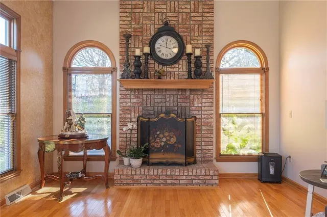 a living room with furniture a fireplace and a large window