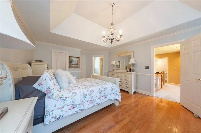 a spacious bedroom with a large bed and a chandelier