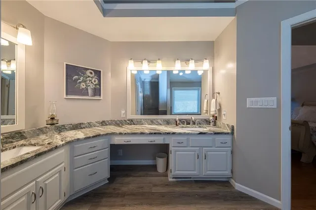 a bathroom with a granite countertop sink and a mirror