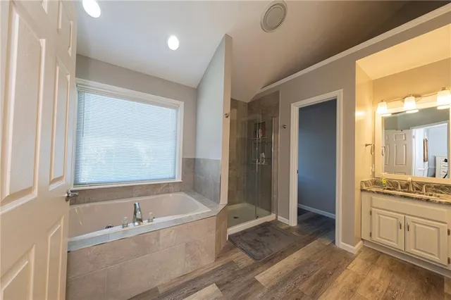 a bathroom with a tub a sink and a large mirror