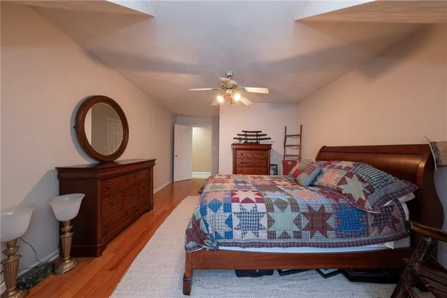a bedroom with a bed a mirror on dresser and a chandelier
