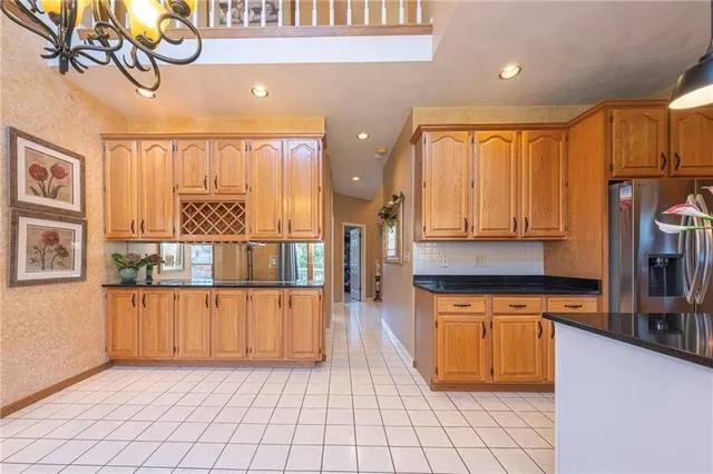 a kitchen with stainless steel appliances granite countertop a coffee maker a sink and a refrigerator