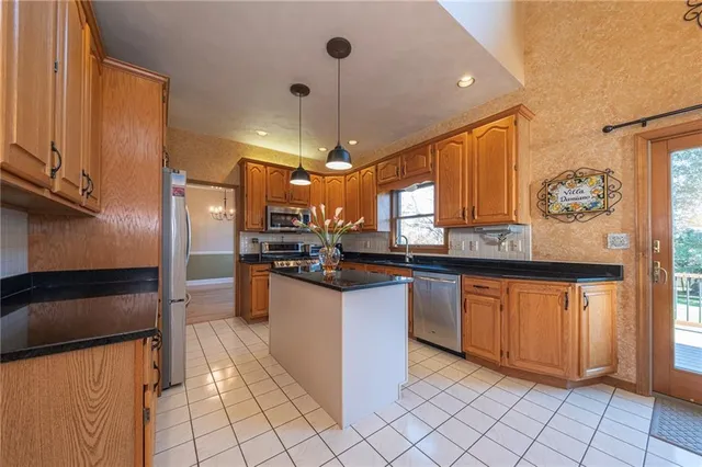 a kitchen with stainless steel appliances granite countertop a refrigerator and a sink