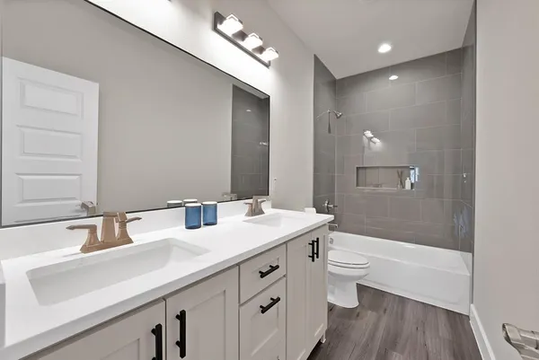 a bathroom with a tub a sink and a large mirror