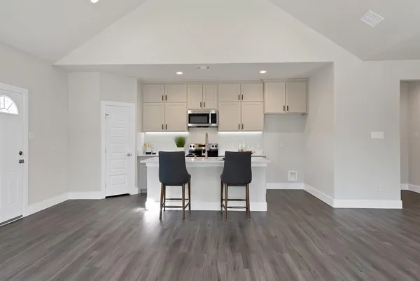 a kitchen with stainless steel appliances wooden floors and refrigerator