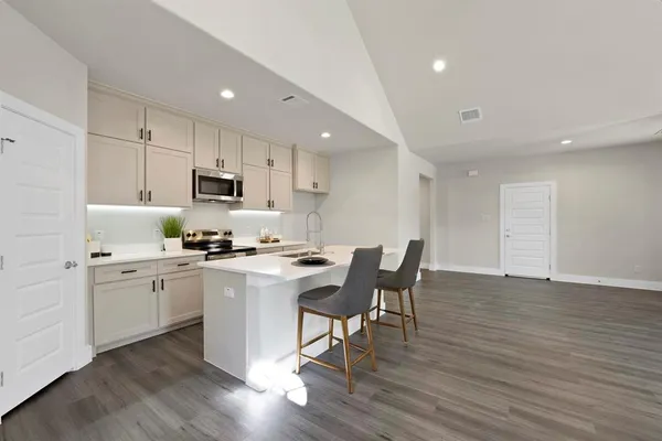 a kitchen with appliances a sink a counter top space and cabinets