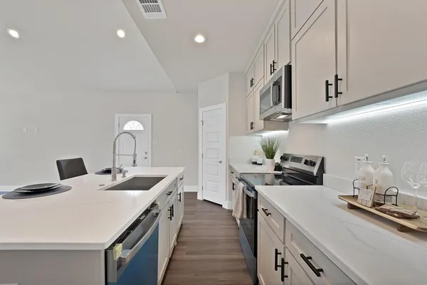 a kitchen with stainless steel appliances a sink a stove and a refrigerator
