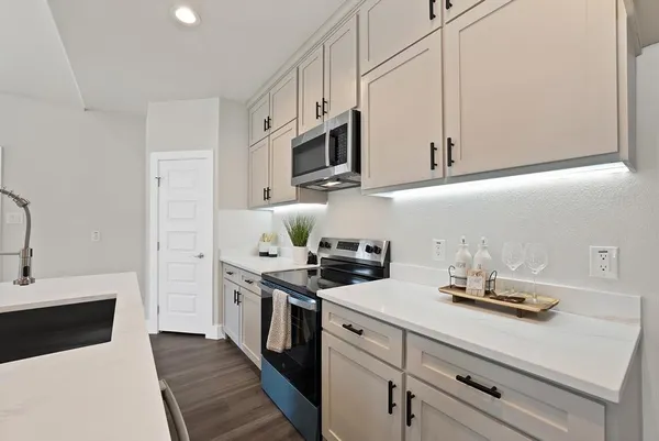 a kitchen with stainless steel appliances a sink stove top oven and cabinets