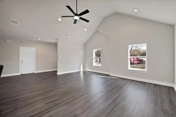 an empty room with wooden floor and ceiling fan