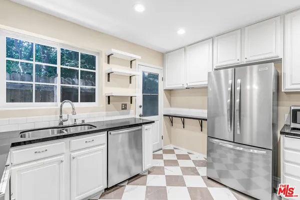 a kitchen with cabinets stainless steel appliances and a counter space