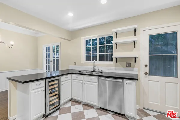a kitchen with granite countertop a sink and cabinets