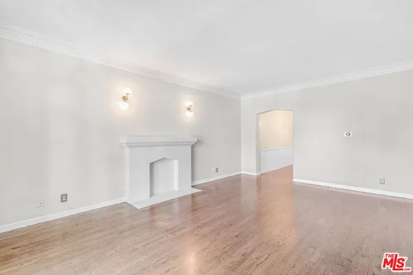 a view of empty room with wooden floor and fireplace