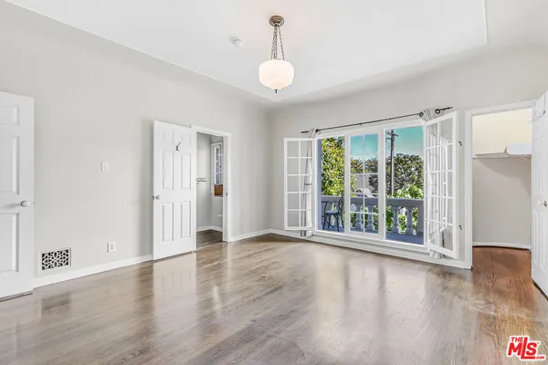a view of an empty room with wooden floor