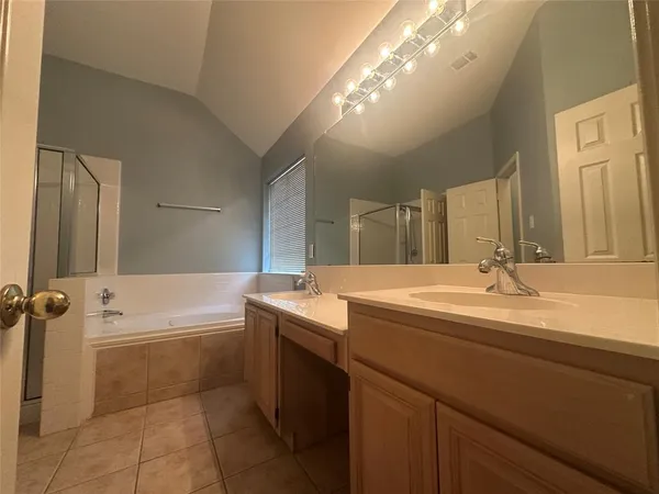 a spacious bathroom with a tub sink and mirror