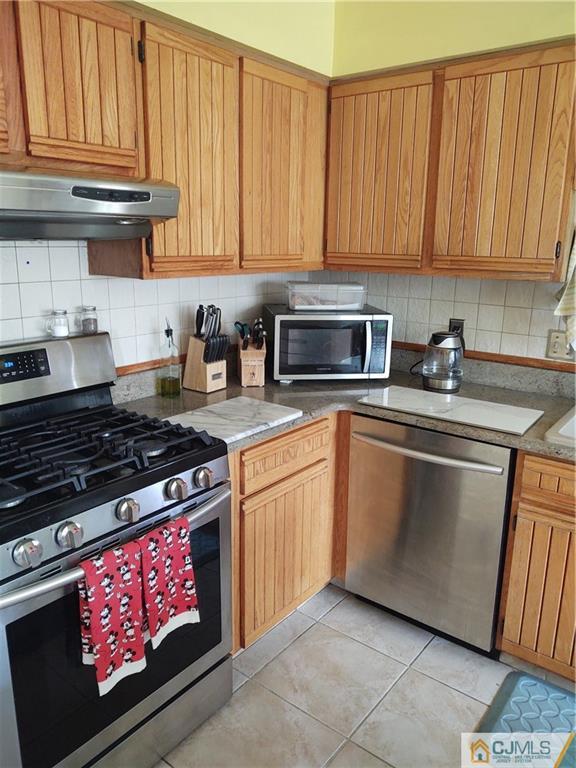 126 Moretti Lane Edison, NJ 08817 - Photo 14 of 33 a kitchen with granite countertop a stove top oven microwave and cabinets