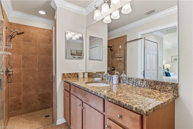 a bathroom with a granite countertop sink a mirror and shower