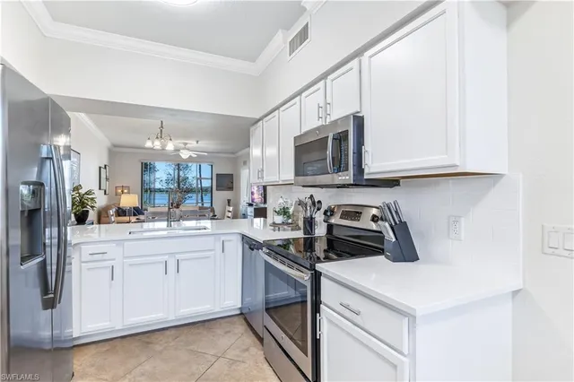 a kitchen with white cabinets and white appliances