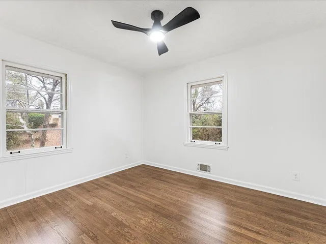 a view of an empty room with wooden floor