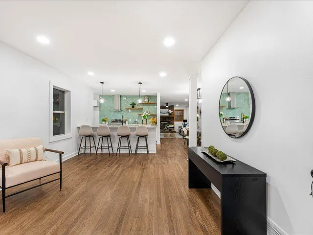 a living room with furniture and a wooden floor