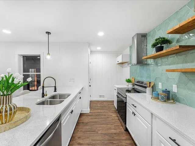 a kitchen with sink a stove and cabinets