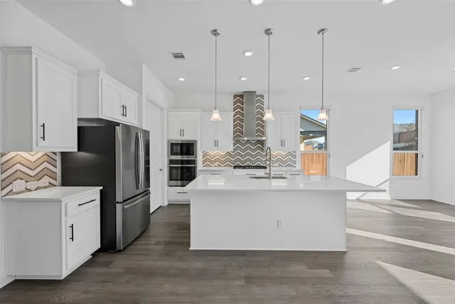 a view of kitchen with stainless steel appliances granite countertop cabinets and wooden floor