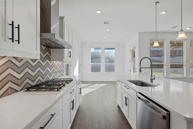 a kitchen with stainless steel appliances granite countertop a sink and stove