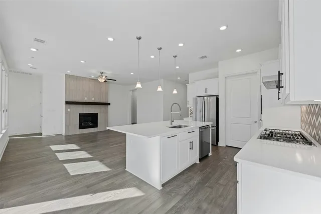 a large white kitchen with a stove a sink and a refrigerator