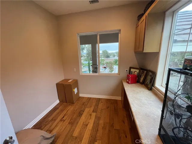 a bedroom with a bed a couch and a flat tv screen on dresser