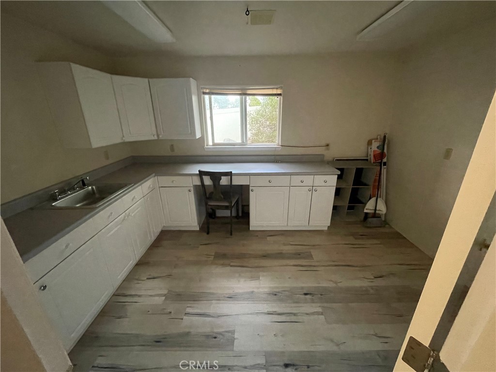 25452 Edna Road Murrieta, CA 92562 - Photo 50 of 70 a large white kitchen with a sink and dishwasher a stove top oven with wooden floor