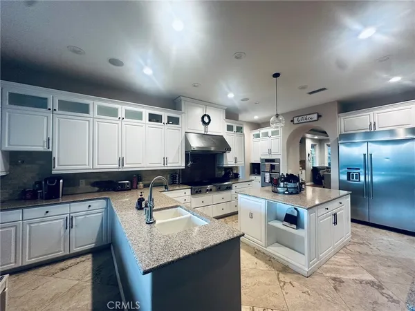 a kitchen with granite countertop a sink a stove and cabinets