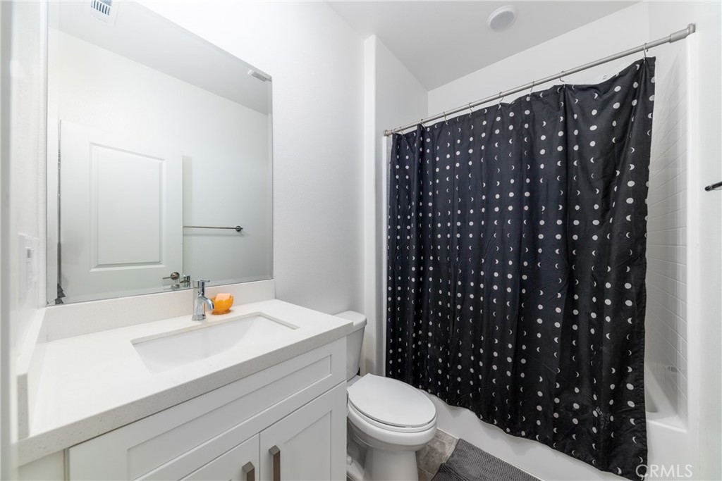1740 Boysen Way Beaumont, CA 92223 - Photo 9 of 49 a bathroom with a sink a toilet and shower curtain