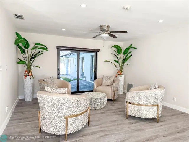 a living room with furniture potted plant and wooden floor