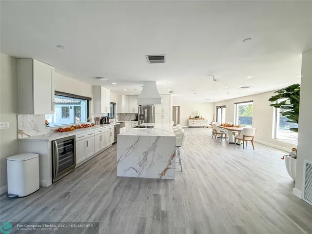 a large white kitchen with lots of counter top space a sink and appliances