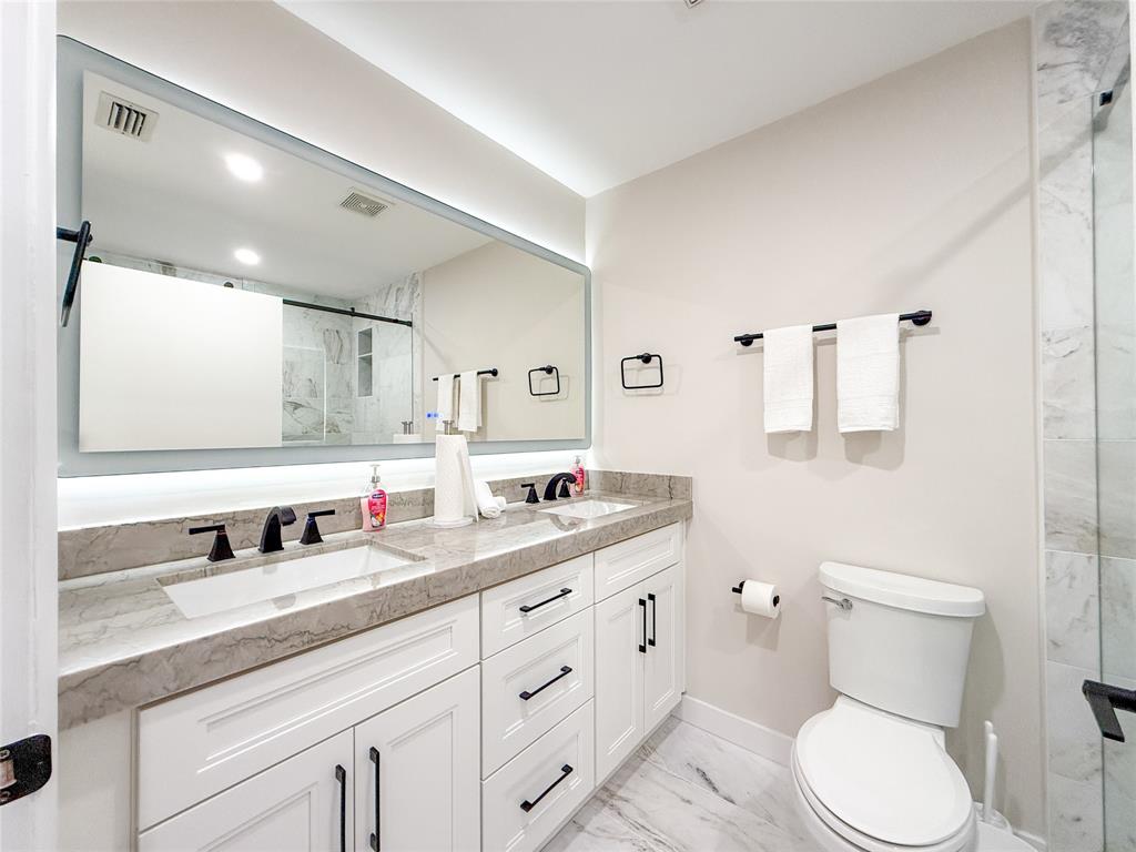 5790 Melaleuca Road Southwest Ranches, FL 33330 - Photo 25 of 44 a bathroom with a toilet sink double vanity and mirror