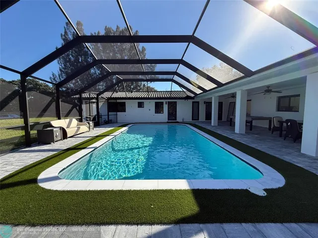 a view of pool with lawn chairs and couches