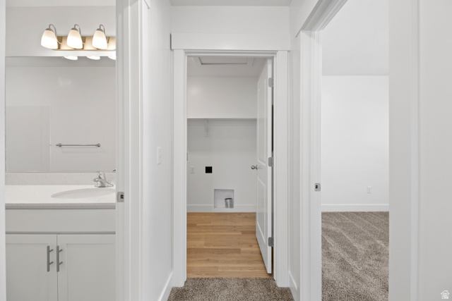 1262 West 500 South Logan, UT 84321 - Photo 16 of 39 Hallway featuring neutral-toned carpeting, leading to a utility space with wood-finish flooring and a white built-in shelf