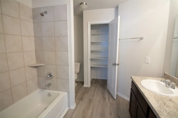 a bathroom with a granite countertop sink a toilet and bathtub