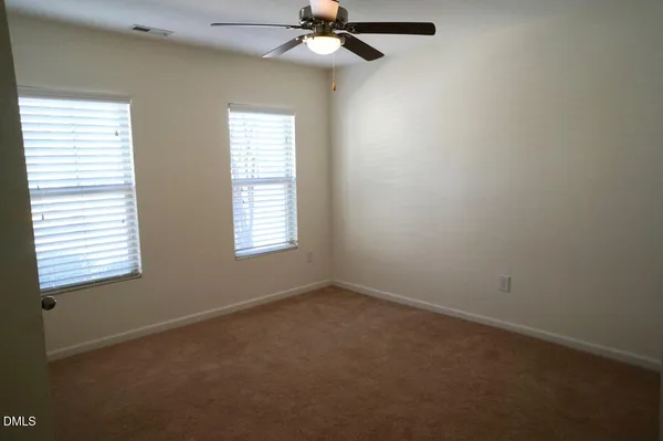 an empty room with a window and a fan