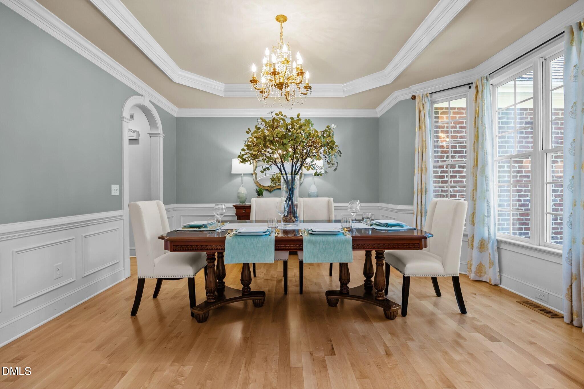3901 Orchard Point Court Apex, NC 27539 - Photo 7 of 53 a view of a dining room with furniture a chandelier and wooden floor