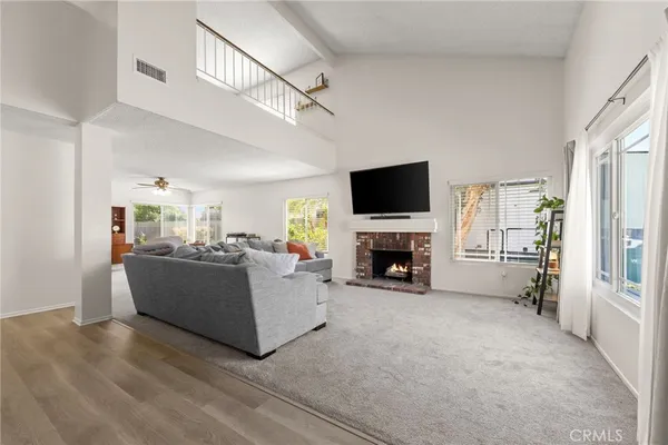 a living room with furniture a flat screen tv and a fireplace